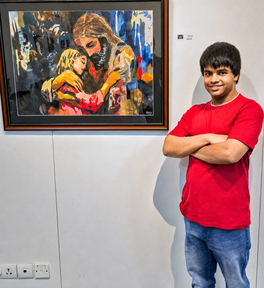 Abheek, the autistic artist who inspired TIIC, standing beside his painting.