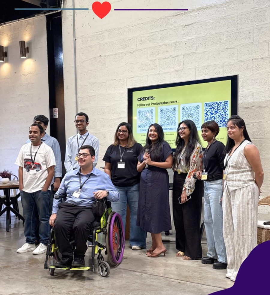 Eight members of the TIIC community, including a wheelchair user, smiling together at an event.