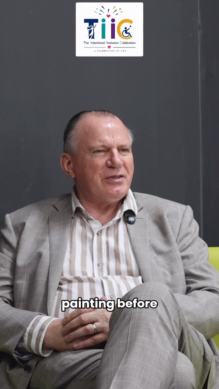 Charles Donald seated in a light grey jacket and striped shirt, mid-sentence, during the filming of the TIIC podcast.
