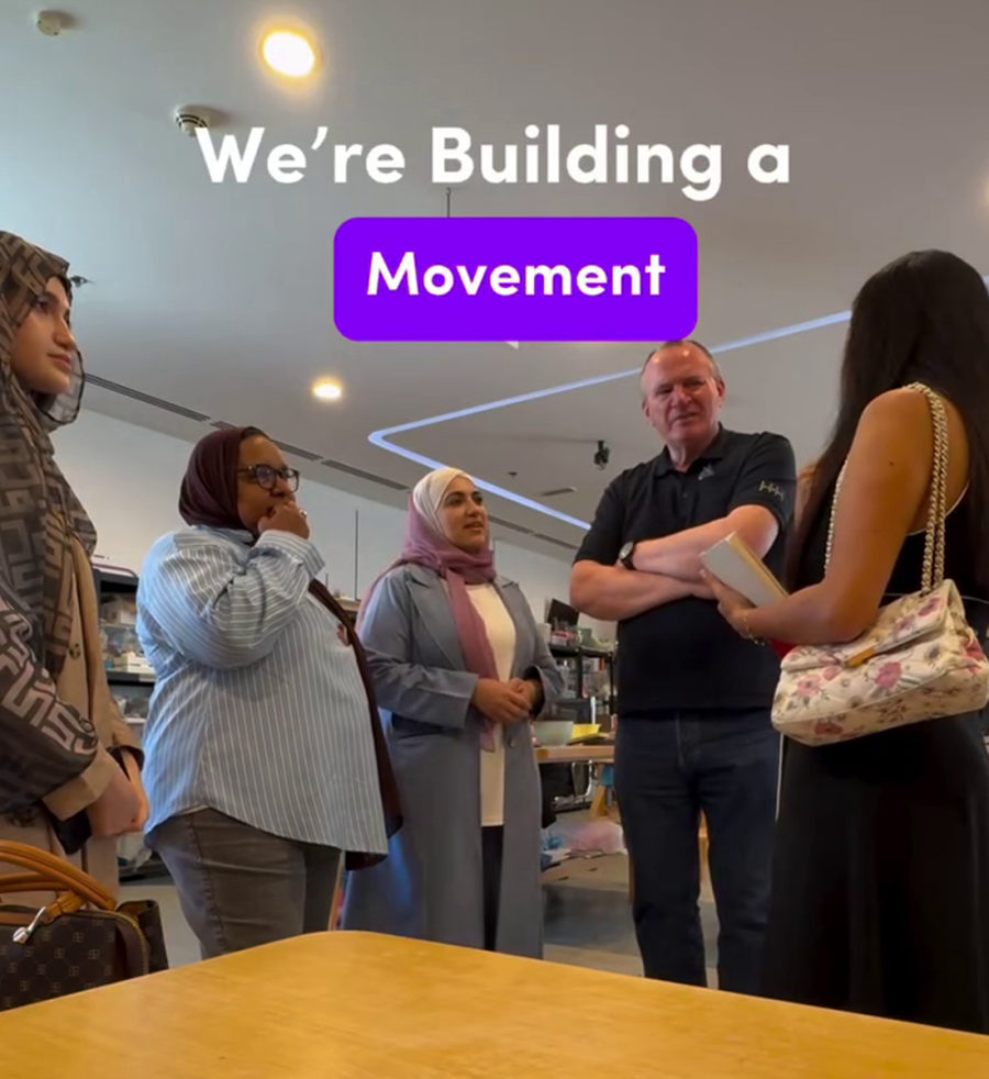 The TIIC team greeting a community partner inside a Dubai marketplace.